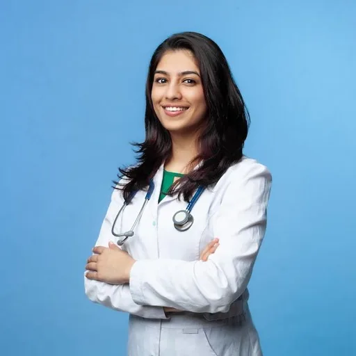 Smiling female audiologist standing with arms crossed, conveying confidence and approachability.